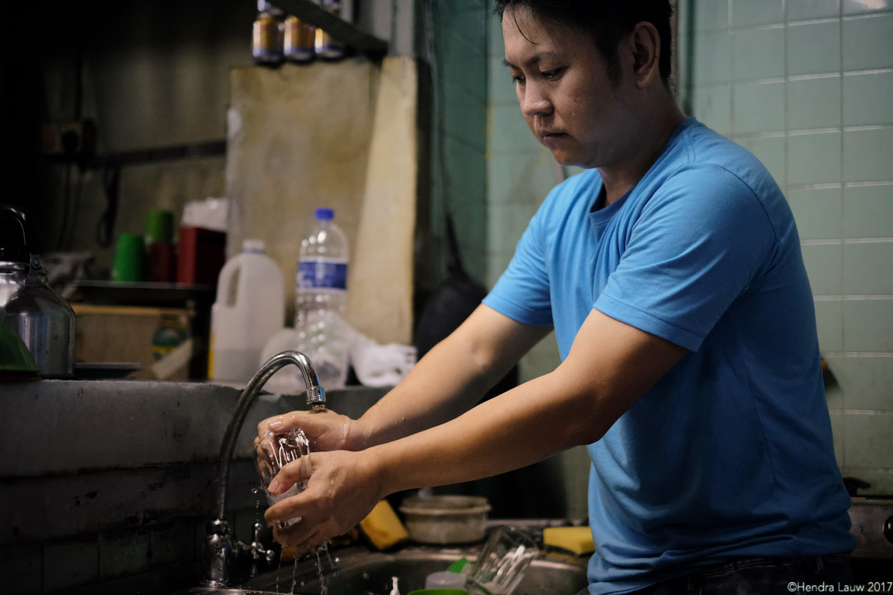 Man washing cups at Hup Lee Coffee Shop in Jalan Besar Singapore.