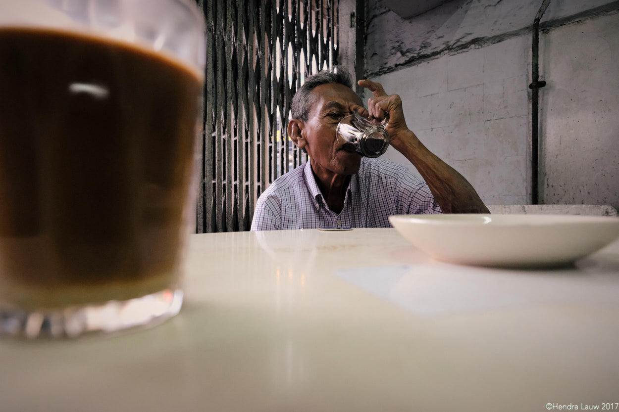 A man drinking coffee at Hup Lee coffee shop in Singapore.