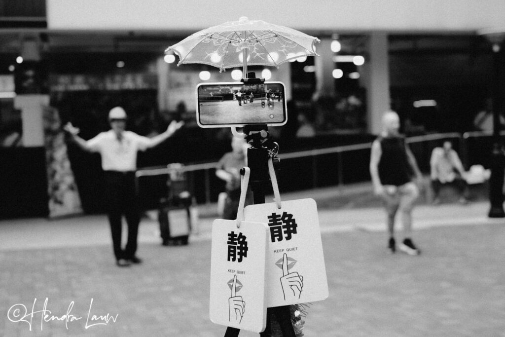 Singapore street photography showing elderly folks dancing and recording themselves in Chinatown